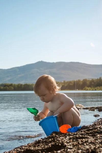 Bebé desnudo jugando en el lago en el verano —  Fotos de Stock