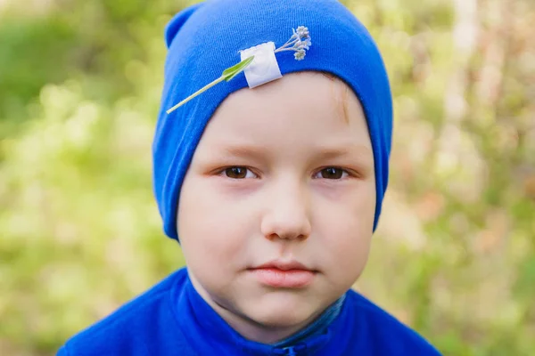 Мальчик в синей шляпе с цветочком на голове во фраках — стоковое фото