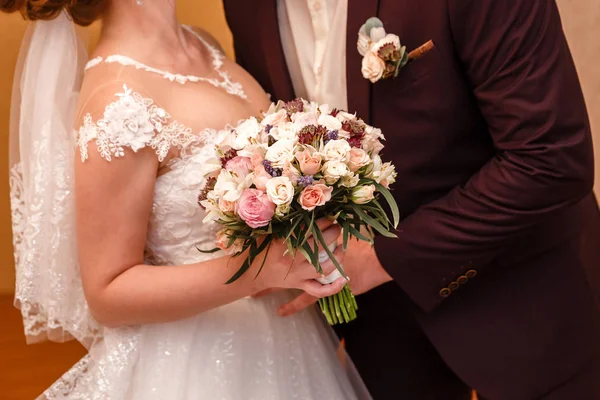 Ženich objímá nevěstu, blízko, svatební kytice — Stock fotografie