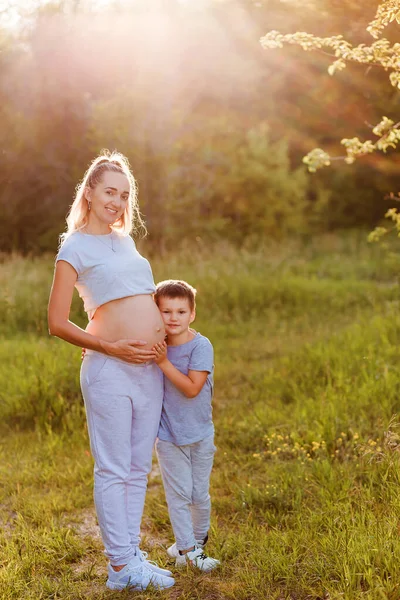 Niño Abraza Vientre Una Mujer Embarazada Verano Parque Una Luz —  Fotos de Stock