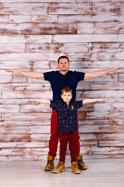 Padre Hijo Misma Ropa Contra Una Pared Madera —  Fotos de Stock