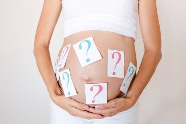 Hamile kadının karnındaki soru işaretleri yakın. Erkek ya da kız