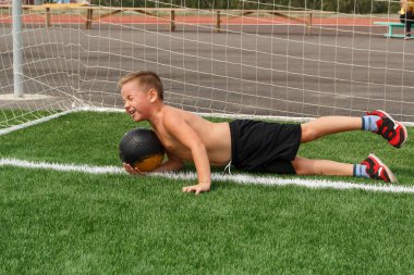 Erkek kaleci stadyumda bir futbol topu yakalar. Futbolda topa düşüyorum.