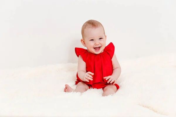 Una Niña Sonriente Ocho Meses Con Traje Rojo Sienta Una —  Fotos de Stock