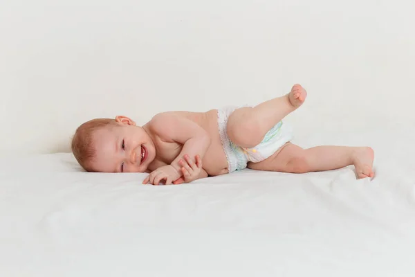 Bebé Sonriente Ocho Meses Pañal Yace Una Sábana Blanca — Foto de Stock