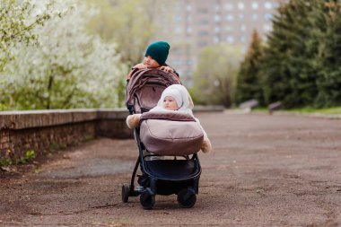 Çocuk dışarıda bir bebek arabasında sabunla yürüyor.