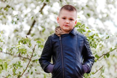 Kısa saçlı yedi yaşında bir çocuk kameraya doğal bir şekilde bakıyor.