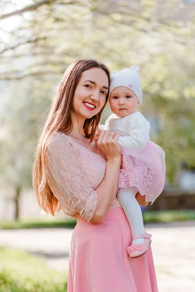 笑顔30歳の女性と赤ちゃんの女の子は自然なぼやけた背景にカメラを見て — ストック写真