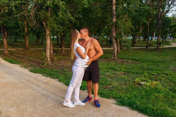 在公园里 一个怀孕的女人在夏天吻了一个汗流浃背的男人 — 图库照片