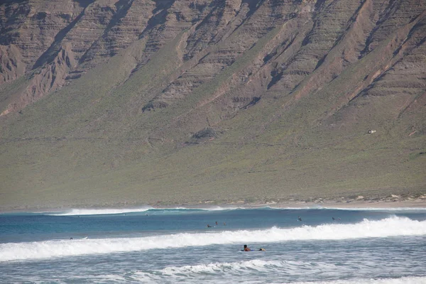 Surfistas y kiters en el mar en la playa de surf Famara —  Fotos de Stock