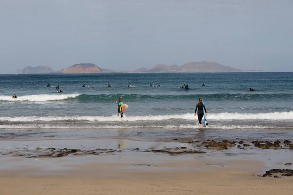 Surfistas y kiters en el mar en la playa de surf Famara —  Fotos de Stock