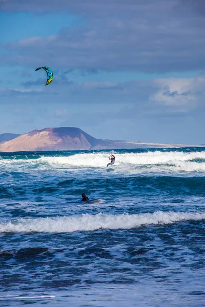Surfers en kiters in de zee op de surf beach Famara op Lanzarote — Stockfoto