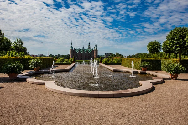 Ein Brunnen in der wunderschönen Parklandschaft rund um das große Schloss — Stockfoto