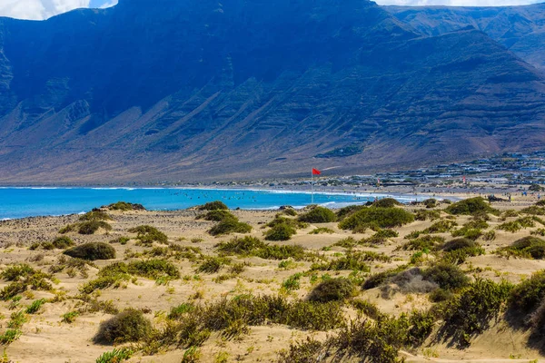 Surferów plażę Famara na Lanzarote zawsze ma czerwoną flagą. — Zdjęcie stockowe