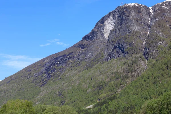 Une magnifique journée de printemps à Loen in Sogn avec des arbres verts et des montagnes enneigées . — Photo