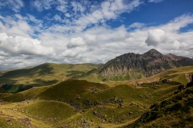 Dağların arasında, vadiyi gören bitki örtüsü olan yüksek bir plato.