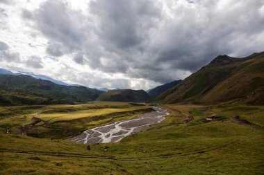 Dağların arasında, vadiyi gören bitki örtüsü olan yüksek bir plato.