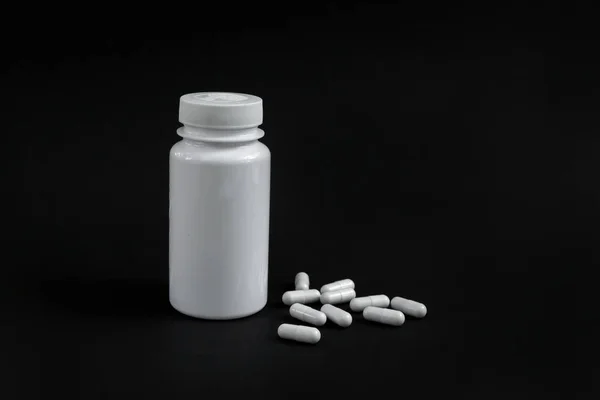 Capsule farmaci con un vaso aperto sullo sfondo — Foto Stock