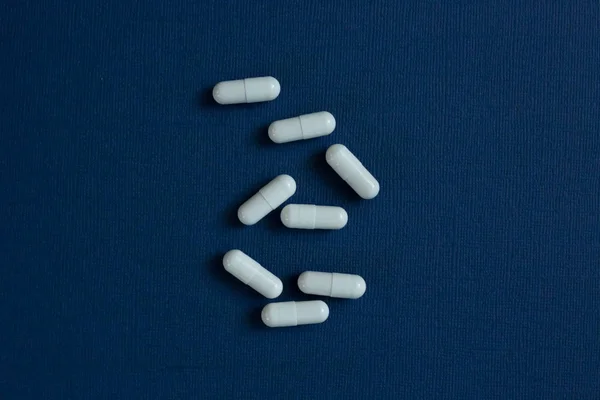 Capsule con medicina su sfondo blu — Foto Stock