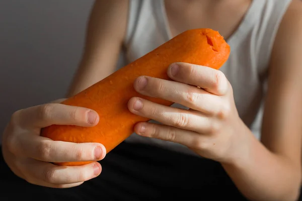 Las manos de los niños sostienen una zanahoria naranja — Foto de Stock