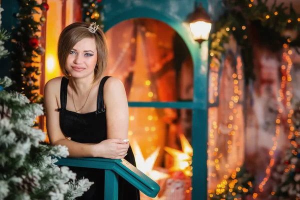 Beautiful girl in evening dress stands on the porch of the house for Christmas and new year — Stock Photo, Image