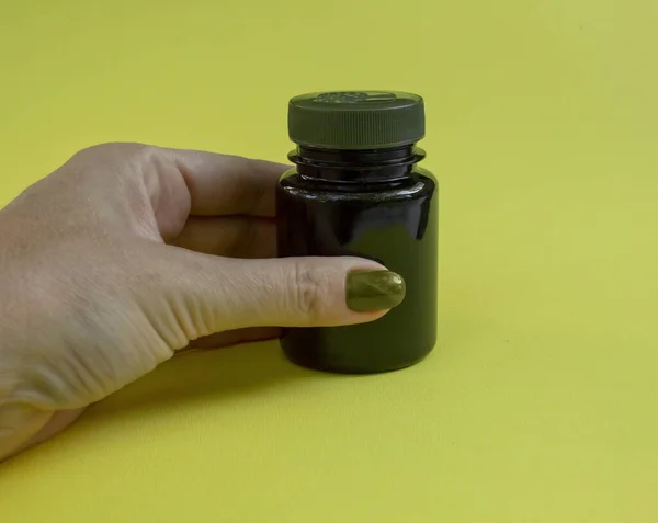 Plastic medicine jar with lid. Holds the hand.