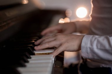 Piyano çalmak için çocuk parmaklarına ve piyano tuşuna özen göster. Konser için müzik aleti ya da öğrenme müziği var. Sahnede piyano çalan çocuk müzisyenin eli kapalı..