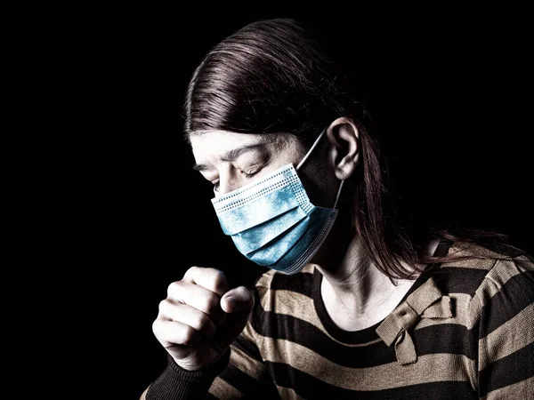 戴口罩的妇女打喷嚏或咳嗽 流行病和恐怖 恐惧或危险的概念 保护生物危害 如Covid 也称为Coronavirus 黑色背景 图库图片