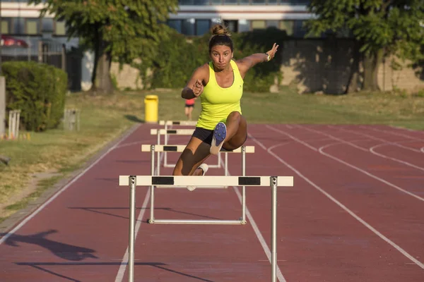 Woman jumping obstacles in athletics — Stock Photo, Image