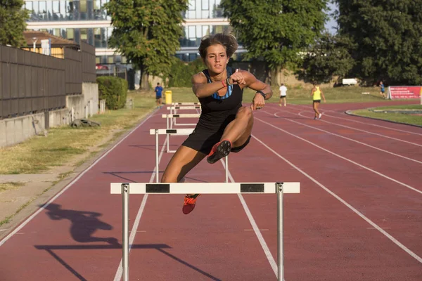 Mulher saltando obstáculos no atletismo — Fotografia de Stock