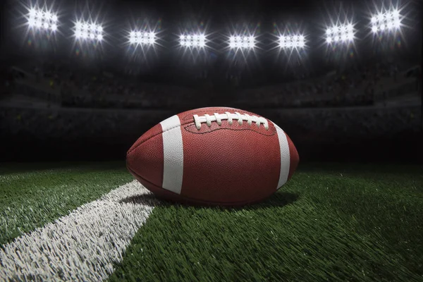 College style football on field with stripe under stadium lights — Stock Photo, Image