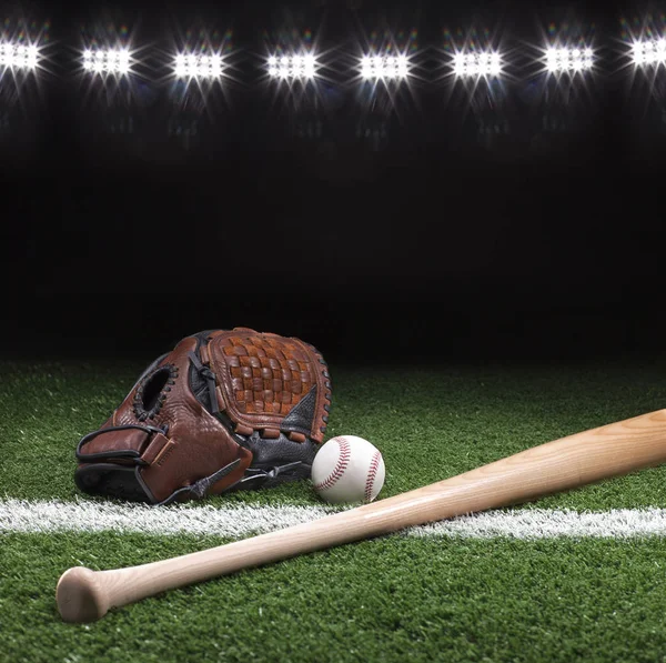 Baseball mitt piłkę i bat w nocy pod Stadion światła — Zdjęcie stockowe