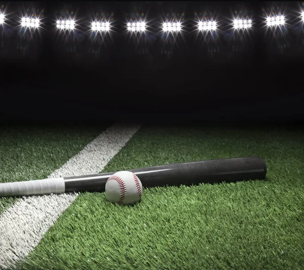Grijze honkbalknuppel en bal op het veld met stadion verlichting — Stockfoto