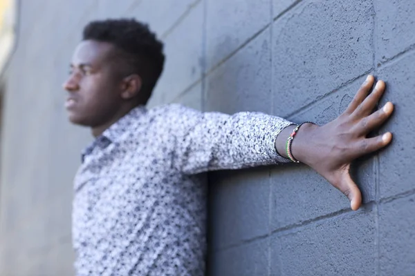 Giovane uomo nero indossa braccialetto bandiera keniota con braccio proteso — Foto Stock