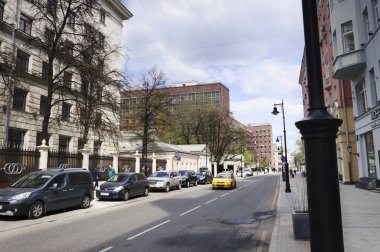 Moskova, Rusya - 01 Mayıs 2016: insanlar yürüyüş Myasnitskaya cadde boyunca bir tatil bahar günü, Yapısalcılık stil, binada görünümü de Corbusier mimar.