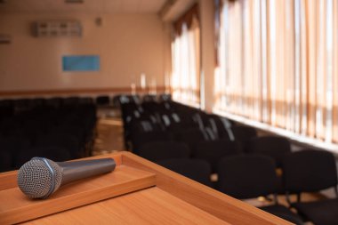 Toplantı odasının önündeki pencereli tribünde mikrofon var.