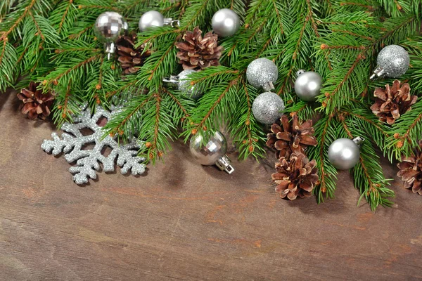 Silver Christmas decorations and spruce branch and cones — Stock Photo, Image