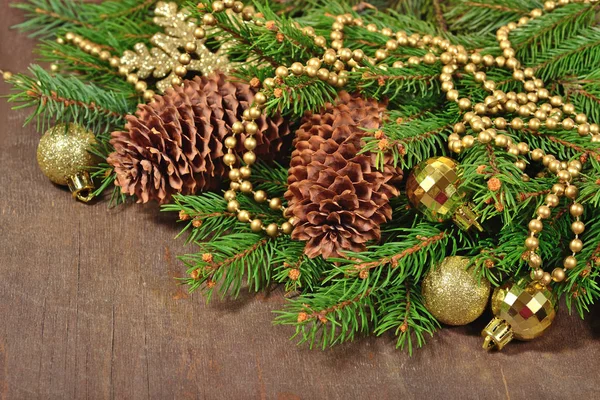 Golden Christmas decorations and spruce branch and cones — Stock Photo, Image