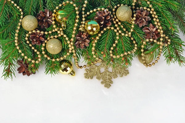 Gyllene juldekorationer och spruce gren och kottar på en wh — Stockfoto