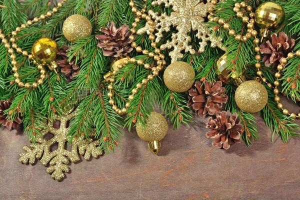 Golden Christmas decorations and spruce branch and cones — Stock Photo, Image