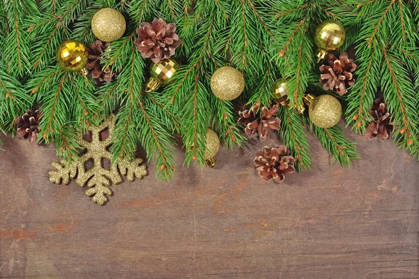 Decoraciones navideñas doradas y ramas de abeto y conos —  Fotos de Stock