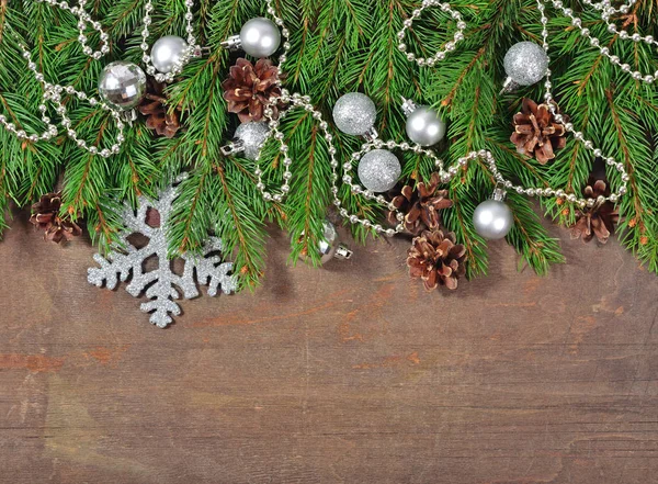 Silver Christmas decorations and spruce branch and cones on a wo — Stock Photo, Image