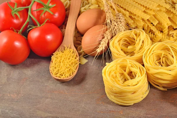 Pastas italianas crudas, rama de tomates maduros y huevos — Foto de Stock