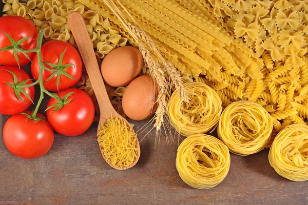 Pastas italianas crudas, rama de tomates maduros y huevos — Foto de Stock