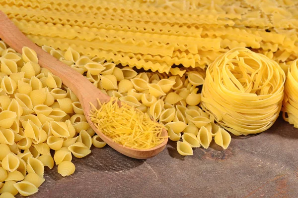 Assortimento di pasta italiana cruda su fondo ligneo — Foto Stock