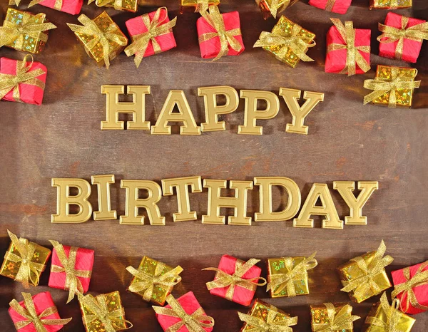 Feliz aniversário texto dourado e presentes dourados e vermelhos — Fotografia de Stock