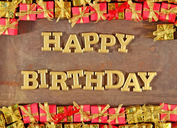 Happy birthday golden text and golden and red gifts — Stock Photo, Image