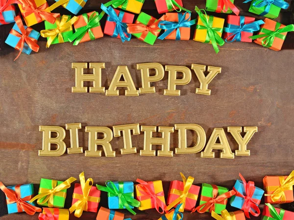 Happy birthday golden text and colorful gifts — Stock Photo, Image