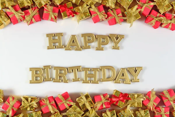 Feliz aniversário texto dourado e presentes dourados e vermelhos em um branco — Fotografia de Stock
