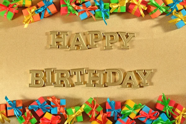 Happy birthday golden text and colorful gifts — Stock Photo, Image